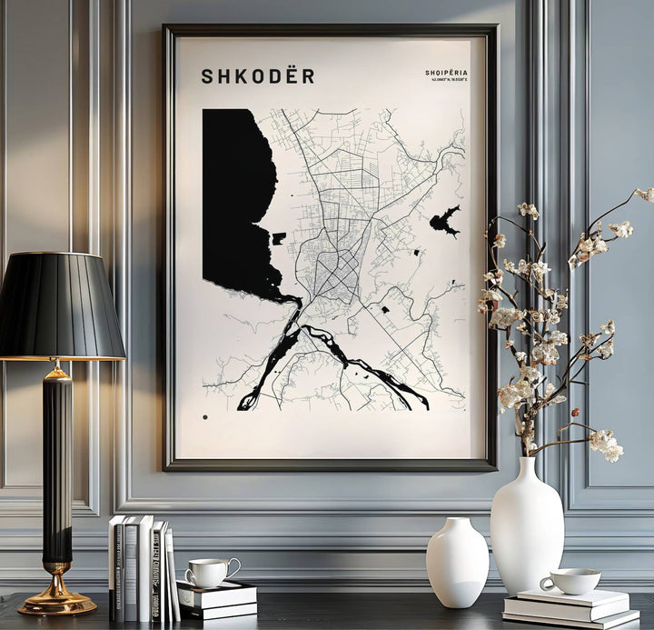 Minimalist street lines and solid black lake silhouettes form a beautiful abstract geometric pattern in this hydrology map poster of Shkodër. MapYourDreams provides flexible choices like unframed archival paper, custom frames in various finishes, and stretched canvas.