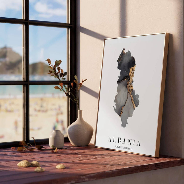 Detailed map art print of Albania with latitude and longitude details, rendered in layered charcoal and metallic gold textures on premium paper stock. Offered by MapYourDreams, this artwork is available in flexible options including unframed paper, custom wooden frames, and gallery canvas wraps.