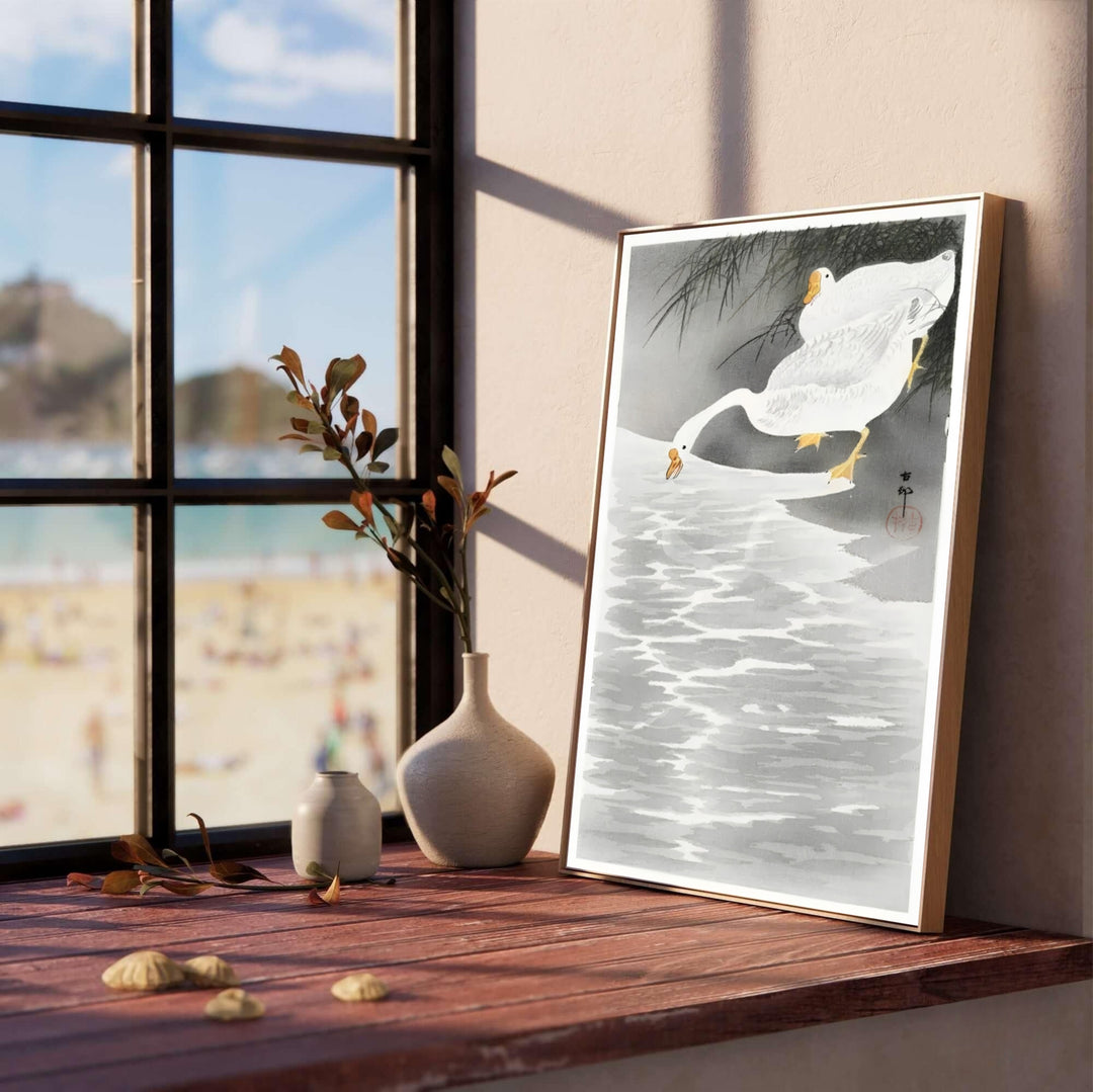 Luminous white geese on water shore print by artist Ohara Koson inspired by historic Tokyo Sumida River bank exhibitions for living room wall decor. Select custom framed, unframed poster, or gallery canvas choices at MapYourDreams.