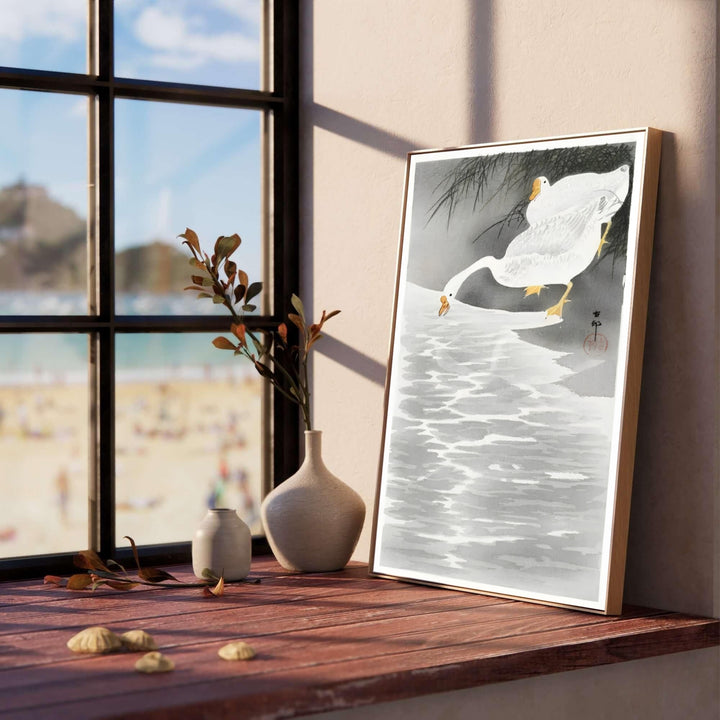 Luminous white geese on water shore print by artist Ohara Koson inspired by historic Tokyo Sumida River bank exhibitions for living room wall decor. Select custom framed, unframed poster, or gallery canvas choices at MapYourDreams.