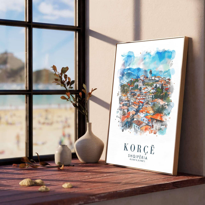 Terracotta shingle roofs and winding cobblestone neighborhoods fill the picturesque cityscape of Korçë, creating a classic European travel poster. Offered in versatile formats including unframed art paper, custom wood framing, and stretched canvas wraps to elevate your space.