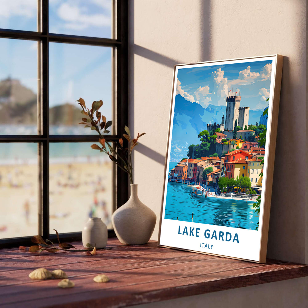 Scenic Italian travel wall art depicting the historic stone tower of Malcesine Castle on Lake Garda, framed by mountains, bright blue water, and sunlit waterfront homes; available to order in flexible display choices including a framed poster, unframed print, or stretched canvas print.
