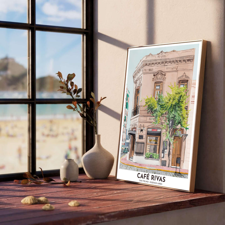 Set against a soft sky blue backdrop, this San Telmo Cafe Rivas wall decor displays the romantic Italianate corner building and leafy sidewalk tree, meticulously crafted by MapYourDreams in fine paper, solid wood framing, and floating canvas choices.