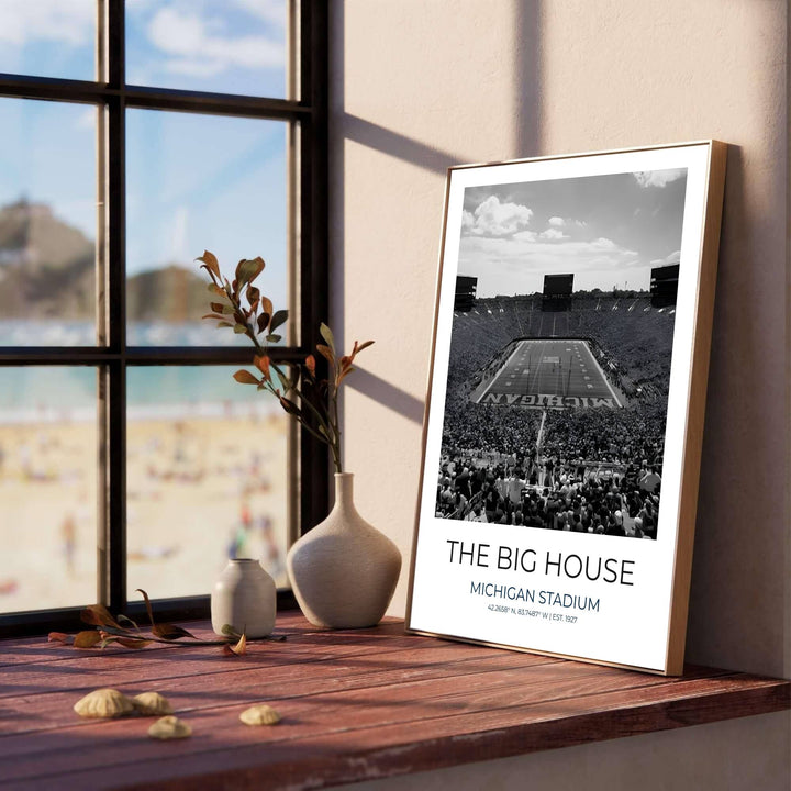 High contrast black and white photo poster depicting University of Michigan Wolverines stadium with painted end zone text. Produced by MapYourDreams, this artwork is available in flexible options including unframed paper, custom wooden frames, and gallery canvas wraps for office wall decor.
