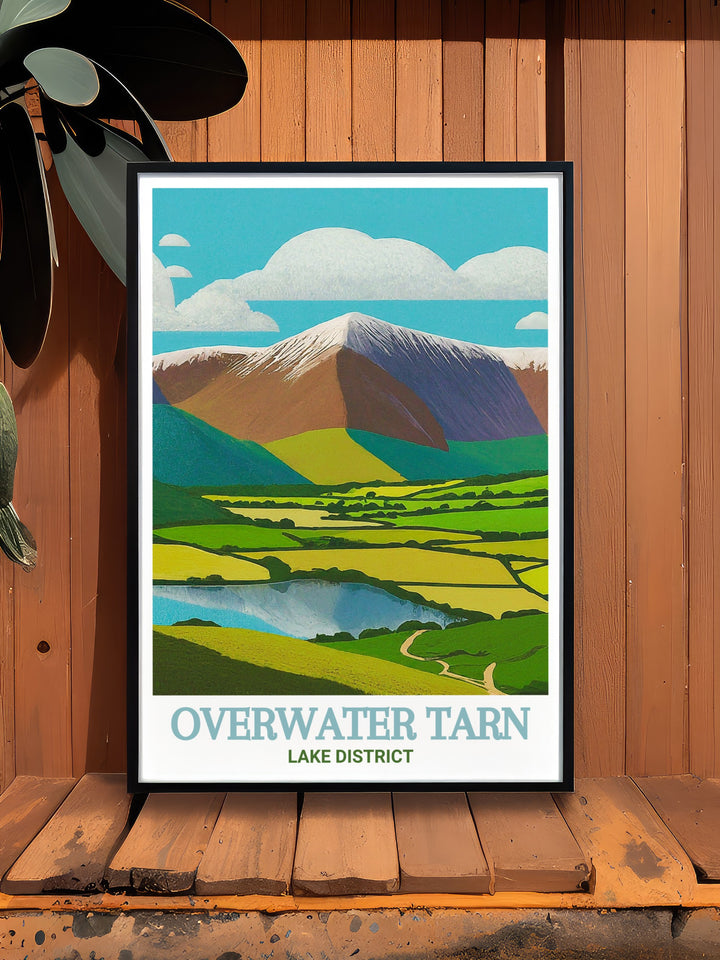 Overwater Tarn wall art capturing the picturesque landscape of the Lake District. This travel print features Overwater Tarn with the Skiddaw fells in the background, creating a calming atmosphere in your home. A beautiful addition for those who appreciate nature.