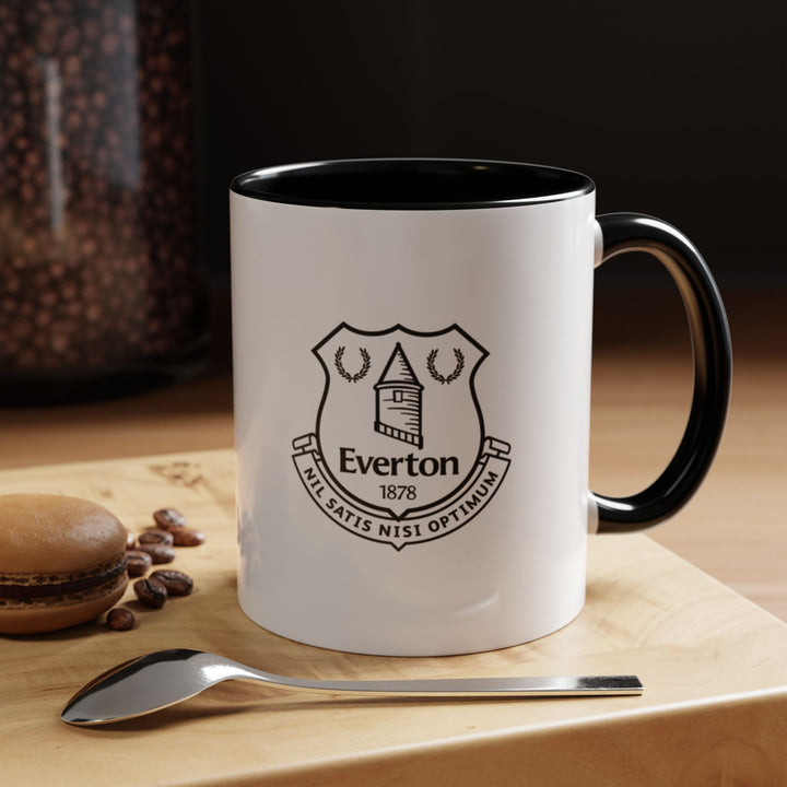 Sleek Everton Coffee Mug in black displaying the official club crest, perfect for dedicated fans of The Toffees. Made of high-quality ceramic with a sturdy handle, it is designed for daily use with coffee, tea, or hot beverages. A stylish fan merchandise item, ideal for gifting, match-day rituals, home or office display, and collectible Everton memorabilia.