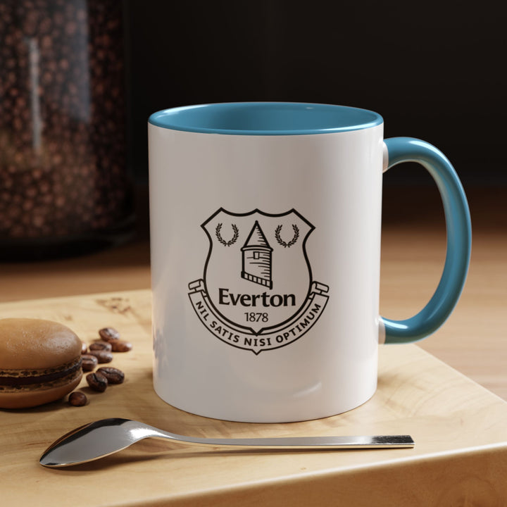 Everton Coffee Mug in classic blue showcasing the official club crest. Perfect for supporters of The Blues to enjoy hot beverages while celebrating team pride. Durable ceramic construction with a comfortable handle ensures everyday usability, whether at home, office, or match-day viewing. A great gift for Everton fans and football merchandise collectors.