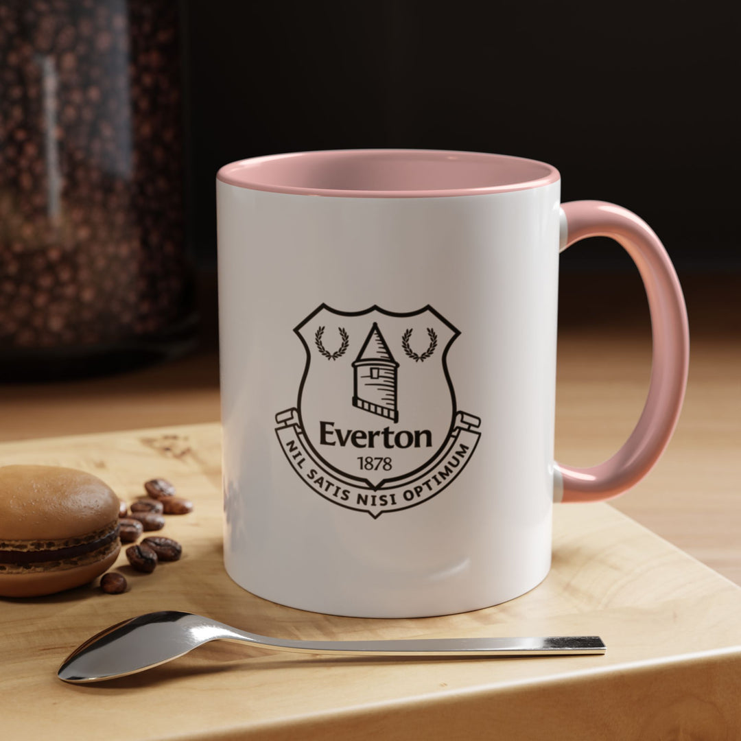 A stylish Everton Coffee Mug in pink featuring the official club crest for fans who enjoy modern and playful designs. Ideal for drinking coffee, tea, or hot chocolate while showing dedication to The Toffees. Durable ceramic with a comfortable handle makes it perfect for everyday use, gift giving, or as a display piece in a football fan’s collection.