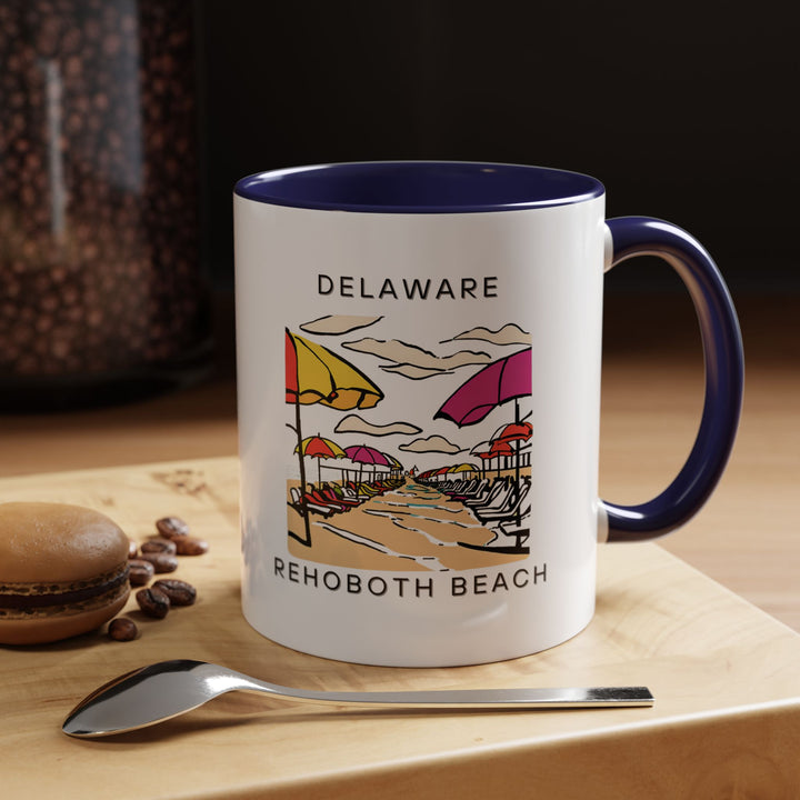 A beautifully designed Rehoboth Beach mug showcasing vibrant artwork of the iconic coastal town. Perfect for coffee or tea lovers, it features detailed imagery of the beach and boardwalk. Dishwasher and microwave safe, it’s an ideal gift for coastal lovers.