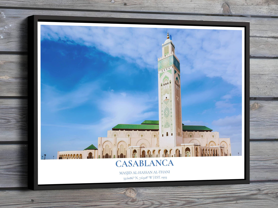 Low angle architectural photography print of Hassan II Mosque in Casablanca Morocco under a bright blue sky with wispy white clouds. Offered by MapYourDreams, this artwork is available in flexible options including unframed paper, custom wooden frames, and gallery canvas wraps for room decor.