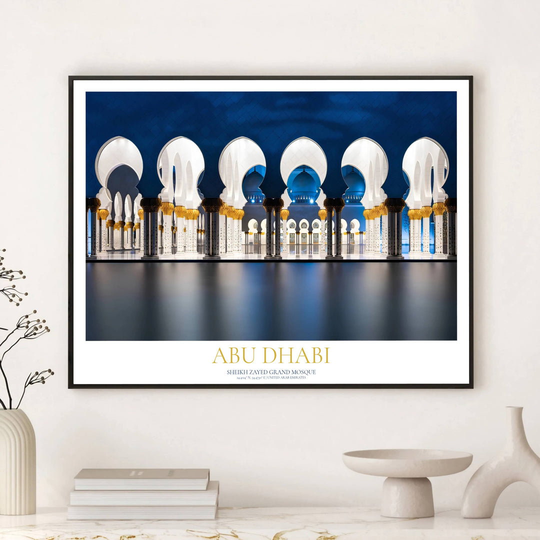 Golden typography Abu Dhabi print showcasing Sheikh Zayed Grand Mosque night arcade reflection. Curated by MapYourDreams, this artwork is obtainable in multiple variants such as unframed paper prints, custom wooden frames, and gallery canvas wraps ideal for office wall decor.