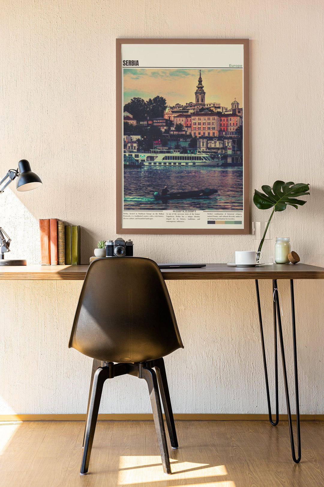 a desk with a chair and a picture hanging on the wall