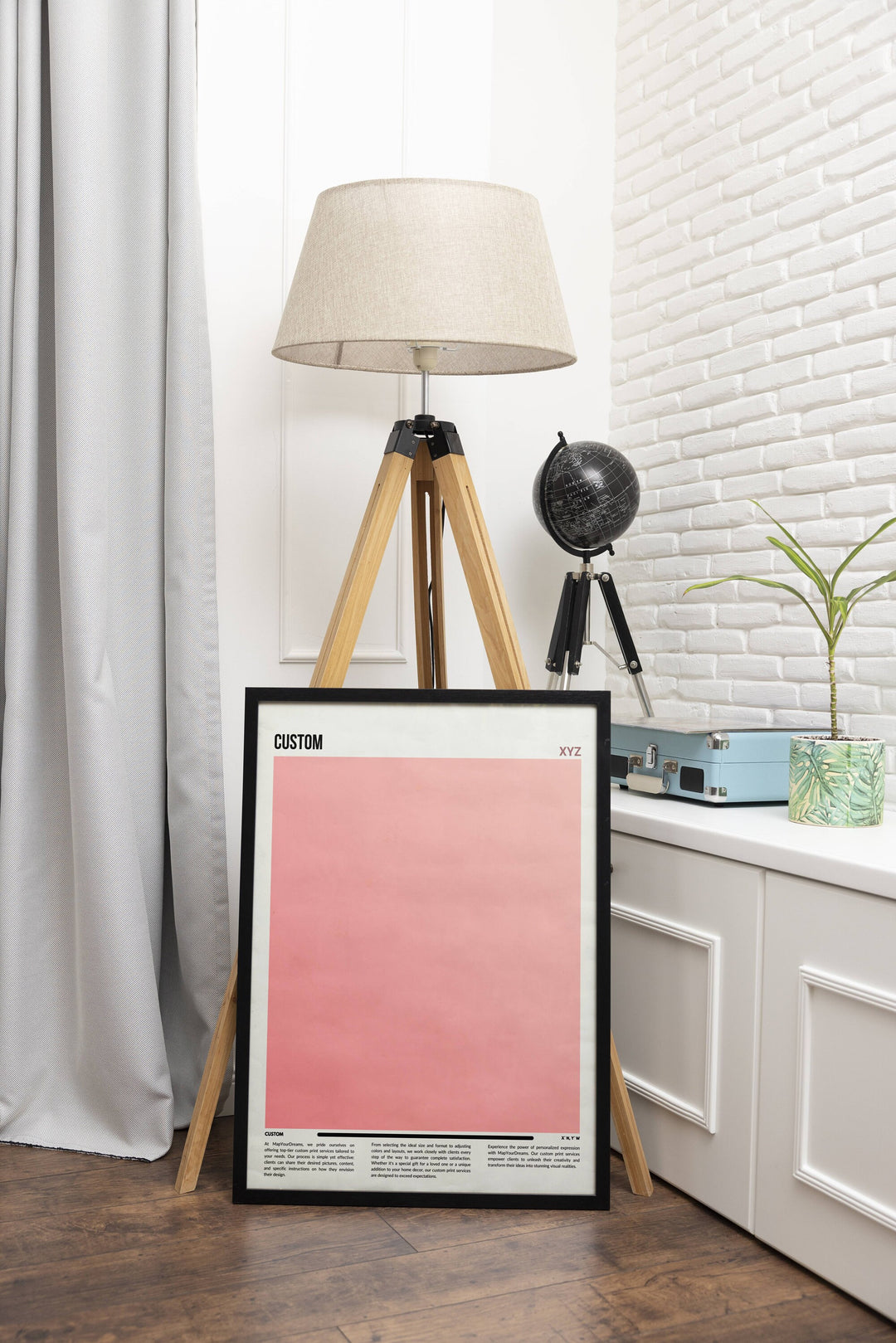 a picture frame sitting on a wooden floor next to a lamp
