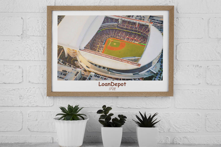 a picture of a baseball stadium hanging on a brick wall