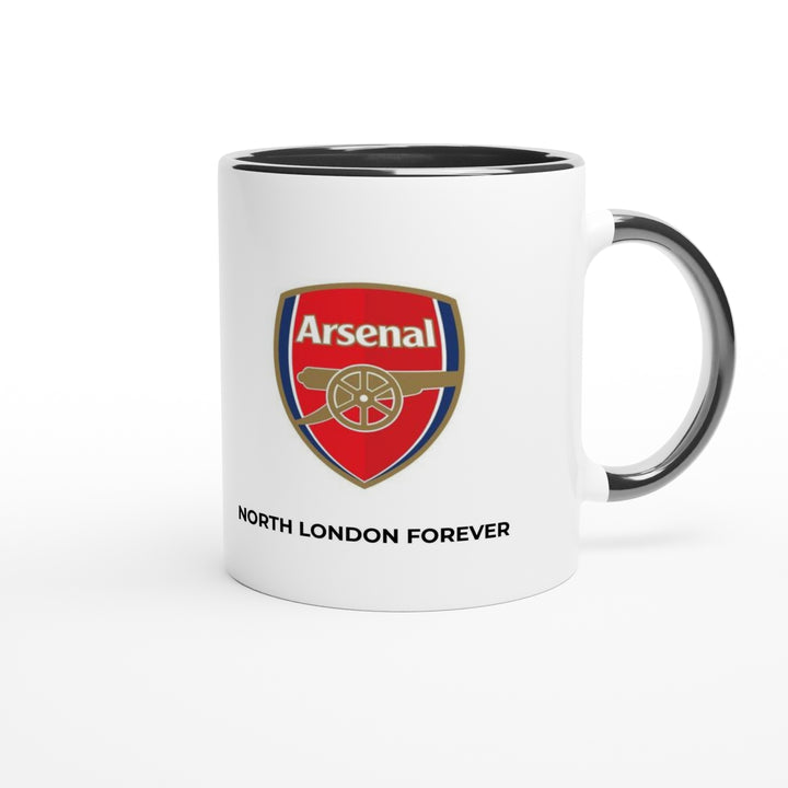 An elegant matte black Arsenal tea mug styled next to a matchday program, showcasing a crisp white text overlay of the famous direct free kick referee quote.