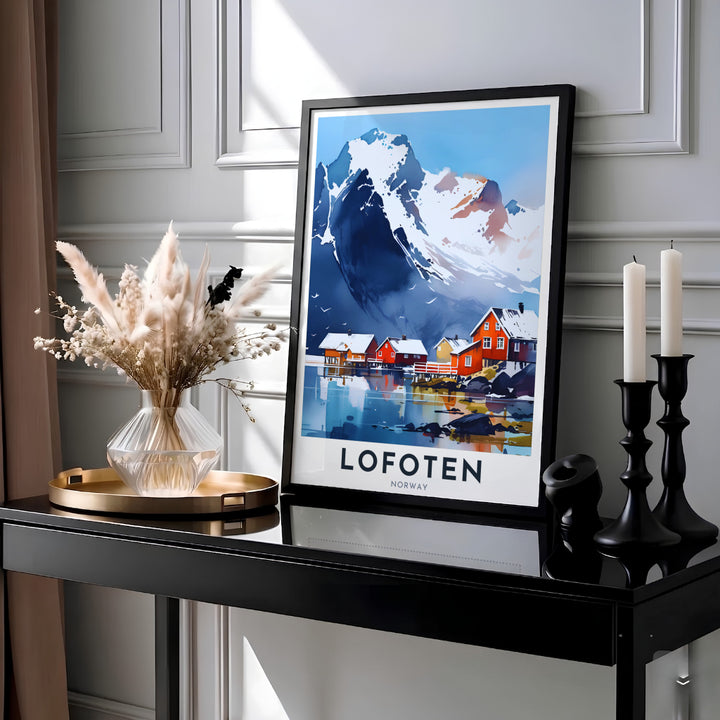 Picturesque coastal view of Lofoten Norway rendered in delicate watercolor washes featuring dramatic snowy cliffs and colorful waterside cabins. This destination art print is crafted for modern interiors, with customizable options as a ready to hang framed poster, stretched canvas wrap, or classic unframed paper print.