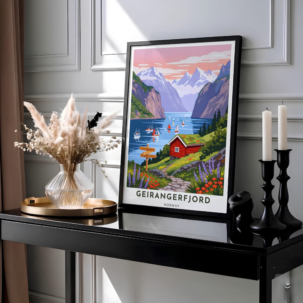 Sunset landscape artwork depicting Geirangerfjord Norway with a traditional turf-roofed house, wooden trail signpost, and sailing boats on peaceful waters. Designed for cozy home interiors, this artwork comes as a ready-to-hang framed poster, stretched canvas wrap, or classic unframed paper print.