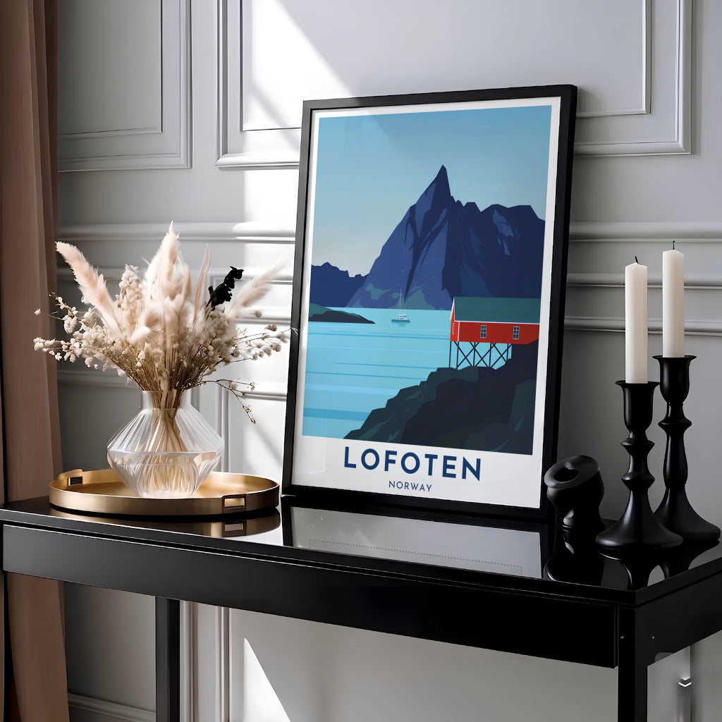 Vector travel print of Lofoten Norway capturing a red stilt cabin along quiet blue waters under a soaring mountain silhouette and clear sky. Designed for modern wall decor, this graphic artwork is available as a lightweight paper poster, custom framed design, or gallery wrapped canvas wrap.