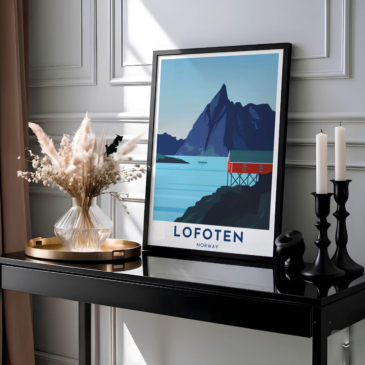Vector travel print of Lofoten Norway capturing a red stilt cabin along quiet blue waters under a soaring mountain silhouette and clear sky. Designed for modern wall decor, this graphic artwork is available as a lightweight paper poster, custom framed design, or gallery wrapped canvas wrap.