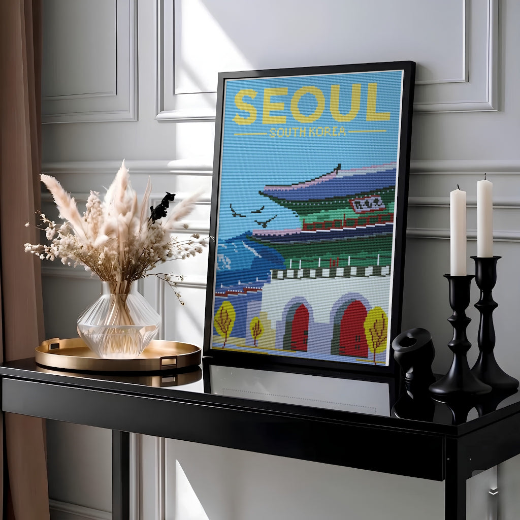 Unique cross-stitch effect print showcasing the historic stone base and arched red doors of Gwanghwamun Gate in Seoul, South Korea, flanked by stylized yellow trees and distant blue mountain peaks. Offered by MapYourDreams, this artwork is available in flexible options including unframed paper, custom wooden frames, and gallery canvas wraps.