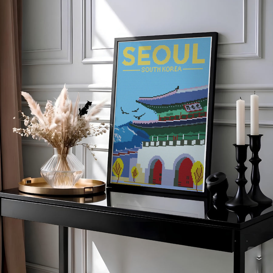 Unique cross-stitch effect print showcasing the historic stone base and arched red doors of Gwanghwamun Gate in Seoul, South Korea, flanked by stylized yellow trees and distant blue mountain peaks. Offered by MapYourDreams, this artwork is available in flexible options including unframed paper, custom wooden frames, and gallery canvas wraps.