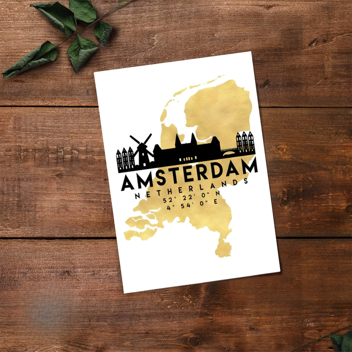 Architectural cartography print of the Netherlands map in faux gold foil with a crisp black skyline of Amsterdam, available from MapYourDreams where you can select between premium unframed paper, gallery canvas, or custom framed wall art options for living room or hallway decoration.
