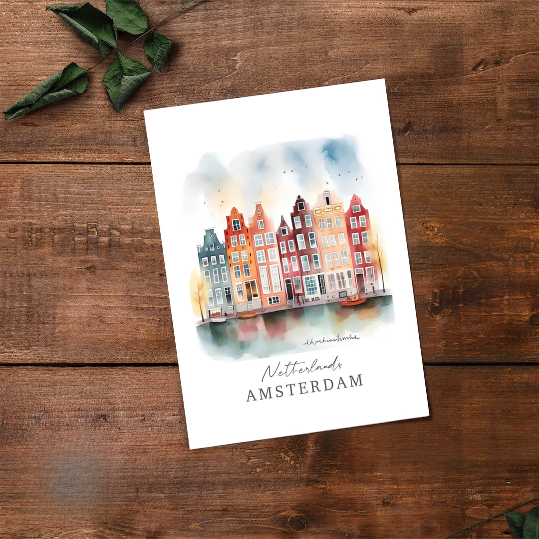 Expressive watercolor travel print of historic Amsterdam canal houses paired with soft water reflections and script lettering, available at MapYourDreams where you can select from unframed paper prints, gallery canvas, or custom framed wall art options for creative spaces.