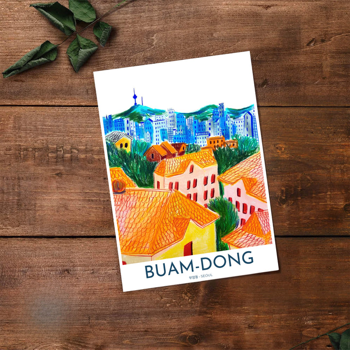 High-contrast hand-drawn city print of Buam-dong, Seoul, presenting warm orange and yellow house facades against electric blue mountain contours and N Seoul Tower. Offered by MapYourDreams, this artwork is available in flexible options including unframed paper, custom wooden frames, and gallery canvas wraps.