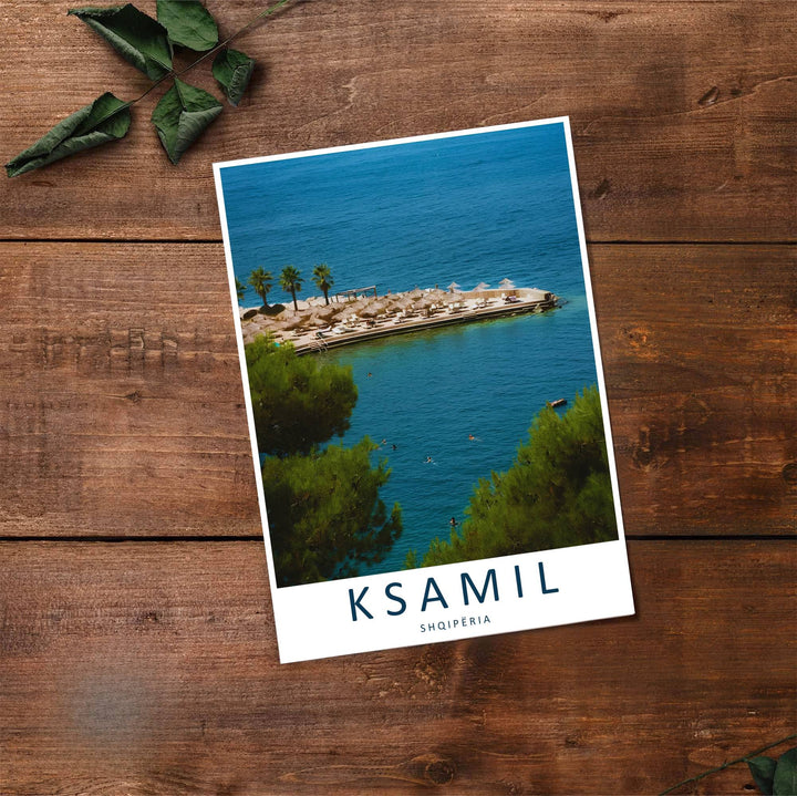 Fine art travel poster showing Ksamil beach with sunny skies, resort piers, and relaxed swimmers displayed across an inviting horizontal view. Choose from flexible display setups including unframed archival paper, wooden frames, or wrapped canvas formats.