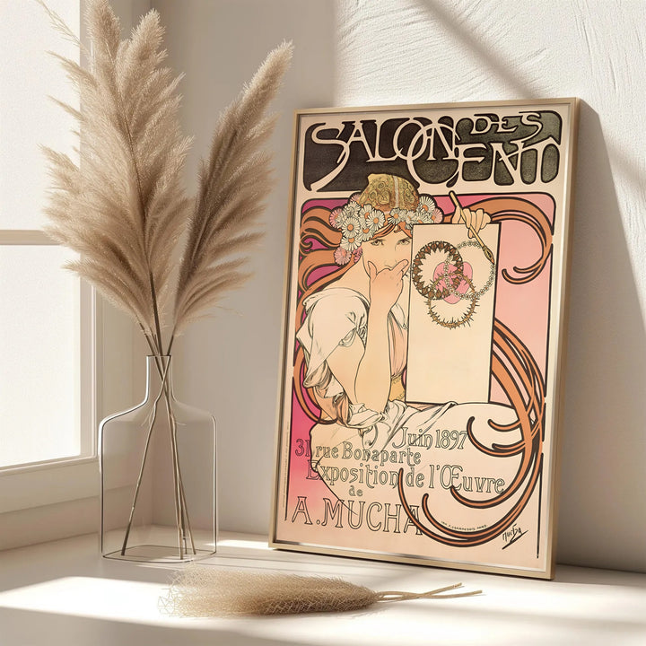 Dynamic Parisian graphic poster Salon Des Cent by artist Alphonse Mucha featuring pink and peach background hues at 31 Rue Bonaparte Paris. MapYourDreams features framed, unframed, and canvas print options for living room wall art.
