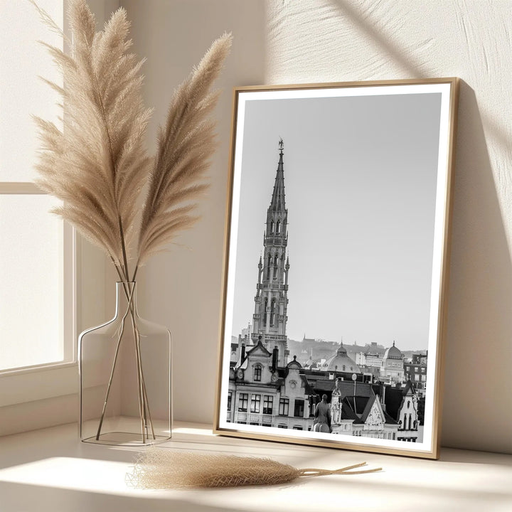 A picturesque Belgian city print showcasing the soaring 15th-century spire rising above city rooftops in Brussels, Belgium. Offered in flexible choices such as unframed archival poster paper, custom wood framing, and gallery canvas wraps.