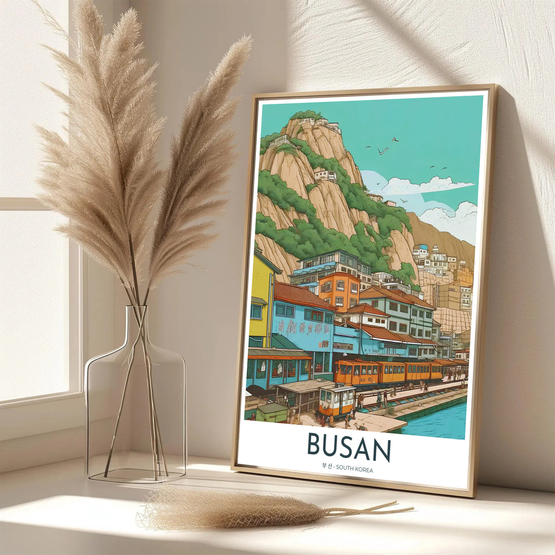 Vibrant South Korean coastal decor print of Busan showcasing the iconic beach train along a pastel hillside neighborhood with birds flying above the bay. Offered by MapYourDreams, this artwork is available in flexible options including unframed paper, custom wooden frames, and gallery canvas wraps.