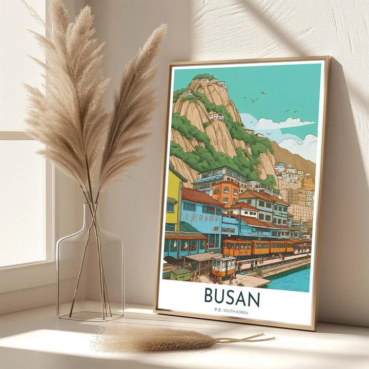Vibrant South Korean coastal decor print of Busan showcasing the iconic beach train along a pastel hillside neighborhood with birds flying above the bay. Offered by MapYourDreams, this artwork is available in flexible options including unframed paper, custom wooden frames, and gallery canvas wraps.