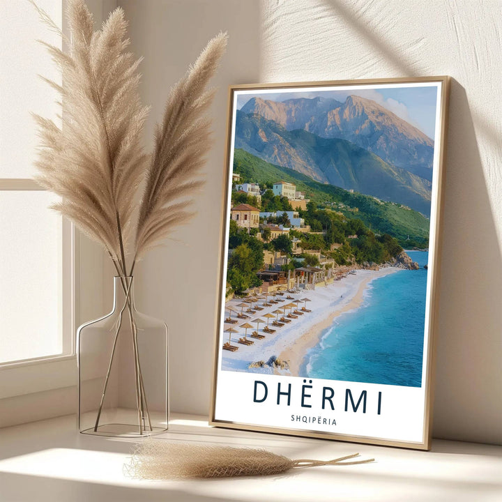 Elegant cartographic typography frames this detailed photograph of Dhërmi Beach, showcasing white shores, green hills, and blue water. Available from MapYourDreams as an unframed paper poster, custom-framed print, or gallery-wrapped canvas.