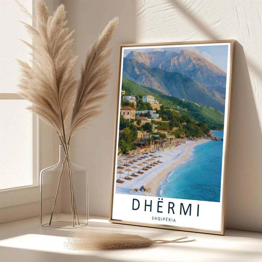 Elegant cartographic typography frames this detailed photograph of Dhërmi Beach, showcasing white shores, green hills, and blue water. Available from MapYourDreams as an unframed paper poster, custom-framed print, or gallery-wrapped canvas.