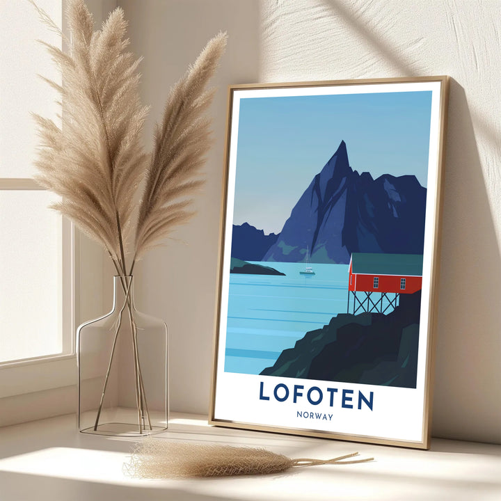 Minimalist travel illustration depicting a red rorbu cabin in Lofoten Norway with a towering mountain peak and calm blue waters. Designed for contemporary interiors, this piece is offered as an unframed paper poster, solid wood framed print, or gallery wrapped canvas wall decor.