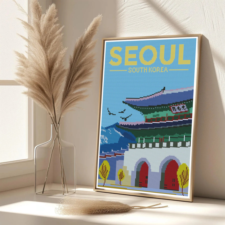 Vibrant cross-stitch South Korean decor print showcasing Gwanghwamun Gate in Seoul surrounded by stylized yellow autumn trees, stone fortress walls, and blue skies. Offered by MapYourDreams, this artwork is available in flexible options including unframed paper, custom wooden frames, and gallery canvas wraps.
