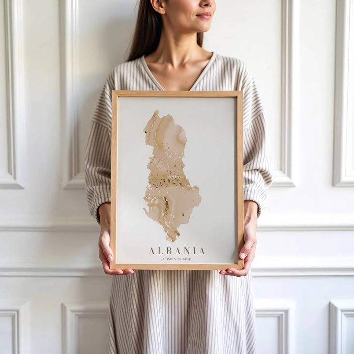 Crisp cartographic artwork showing the country map of Albania in warm beige and metallic gold with modern serif country lettering and coordinates. Offered by MapYourDreams, this artwork is available in flexible options including unframed paper, custom wooden frames, and gallery canvas wraps.
