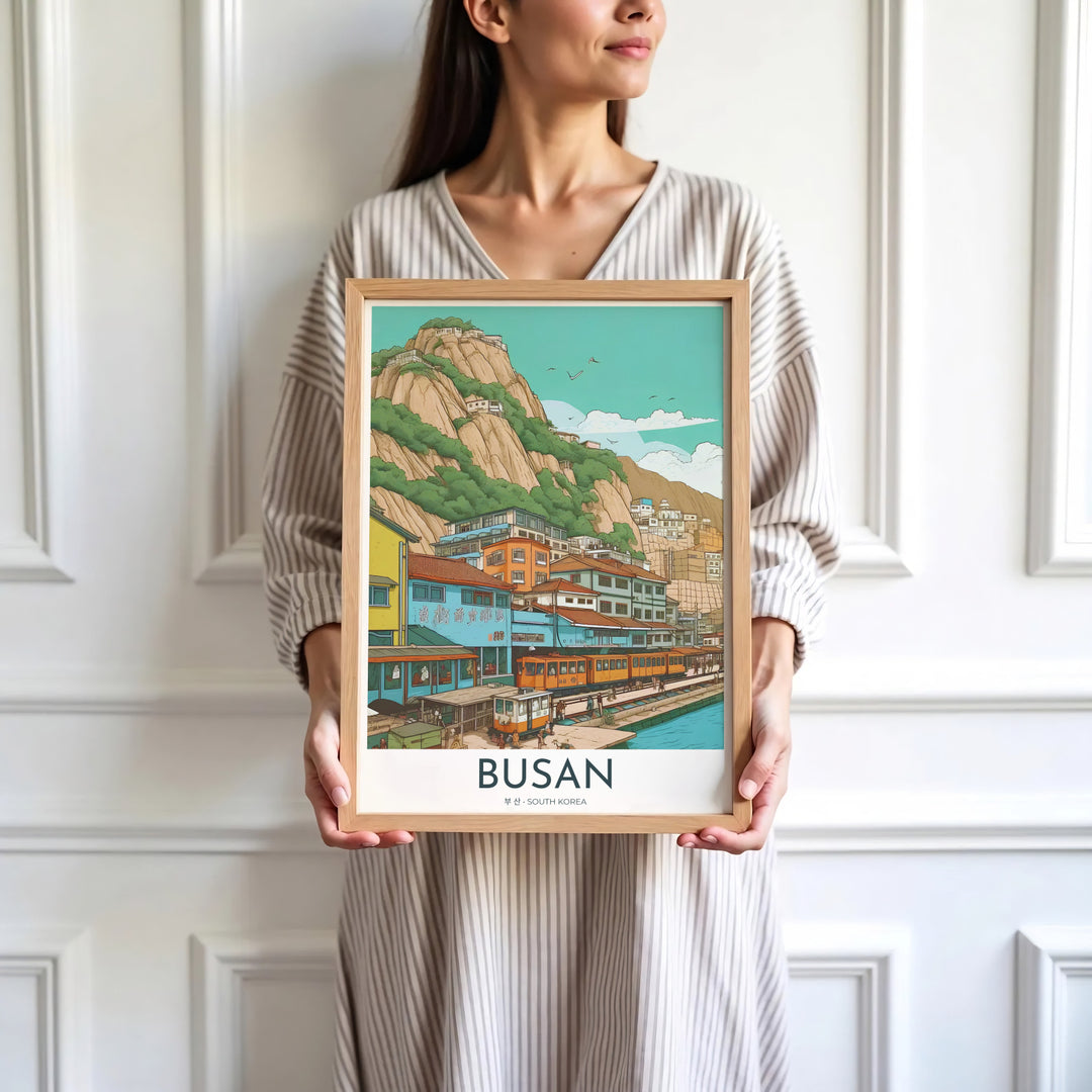 Minimalist white-bordered travel print of Busan, South Korea, showcasing a picturesque coastal scene with trains, sea harbor waters, and cliffside structures. Offered by MapYourDreams, this artwork is available in flexible options including unframed paper, custom wooden frames, and gallery canvas wraps.