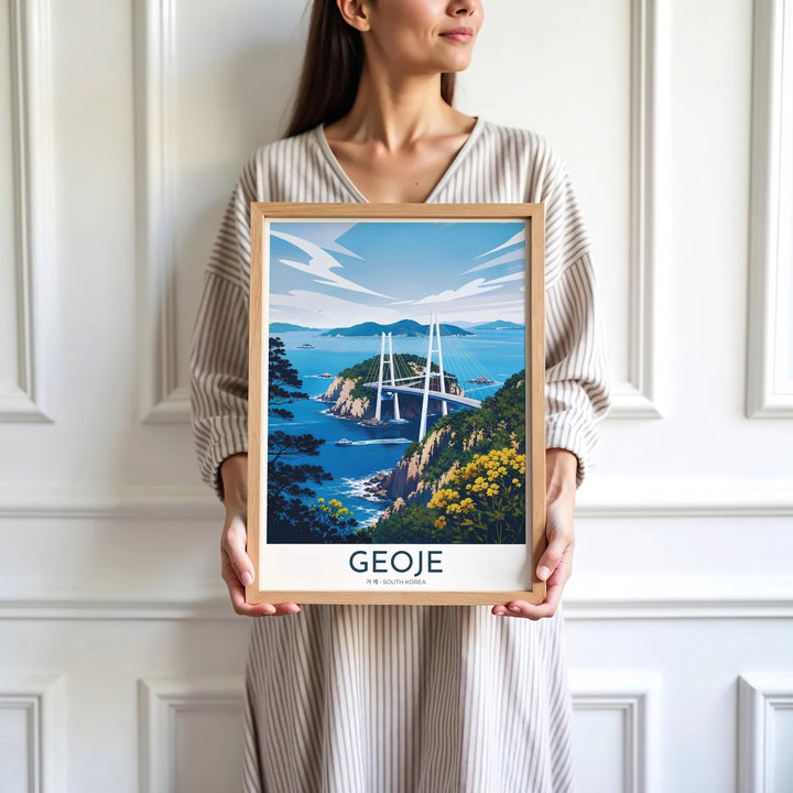 Minimalist white-bordered travel print of Geoje, South Korea, showcasing Geoga Bridge, passing sea vessels, and vibrant cliffside yellow flowers under a bright sky. Offered by MapYourDreams, this artwork is available in flexible options including unframed paper, custom wooden frames, and gallery canvas wraps.