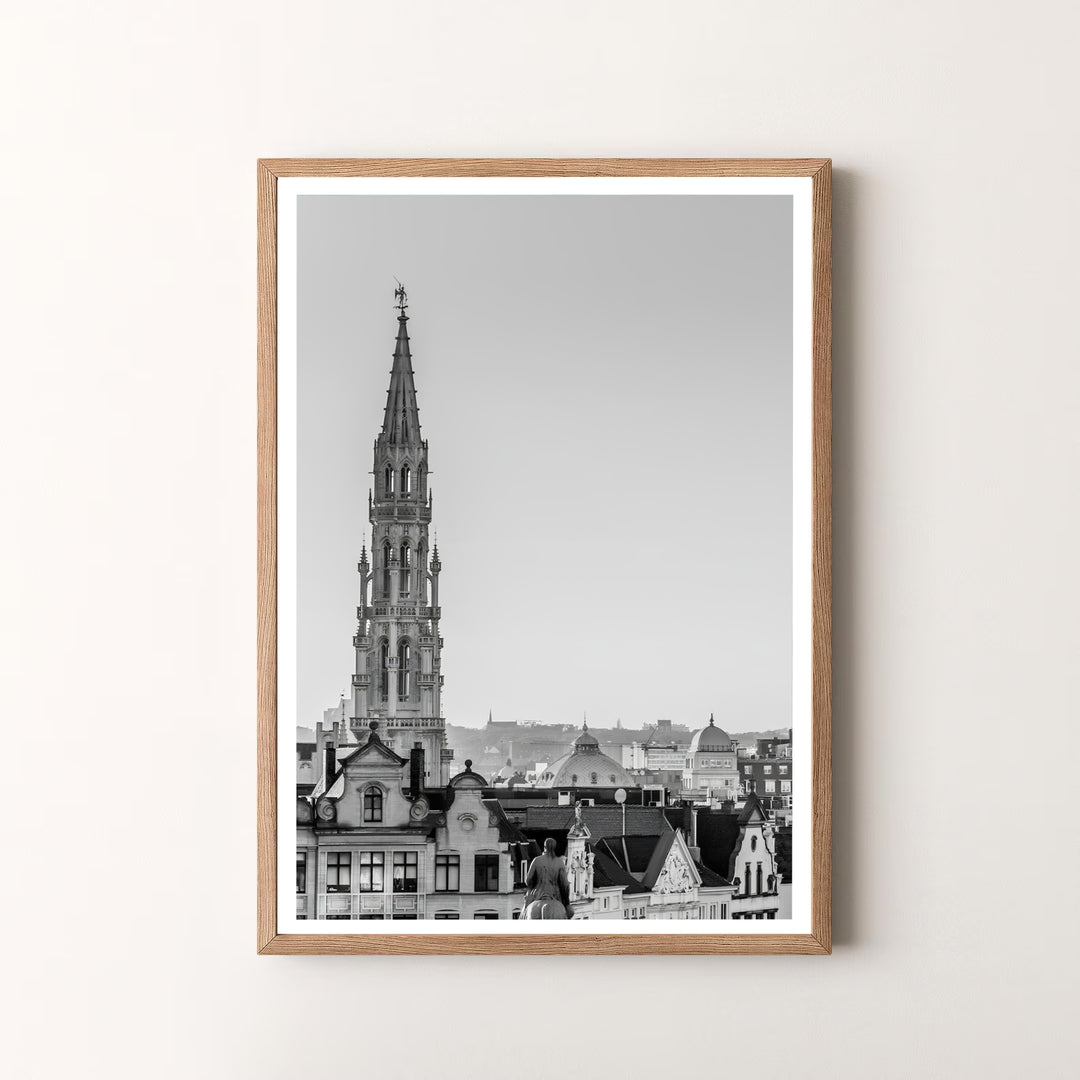 A striking black and white skyline print highlighting the majestic Gothic spire and historic architecture of Brussels, Belgium. Offered by MapYourDreams, this artwork is available in flexible options including unframed paper, custom wooden frames, and gallery canvas wraps.