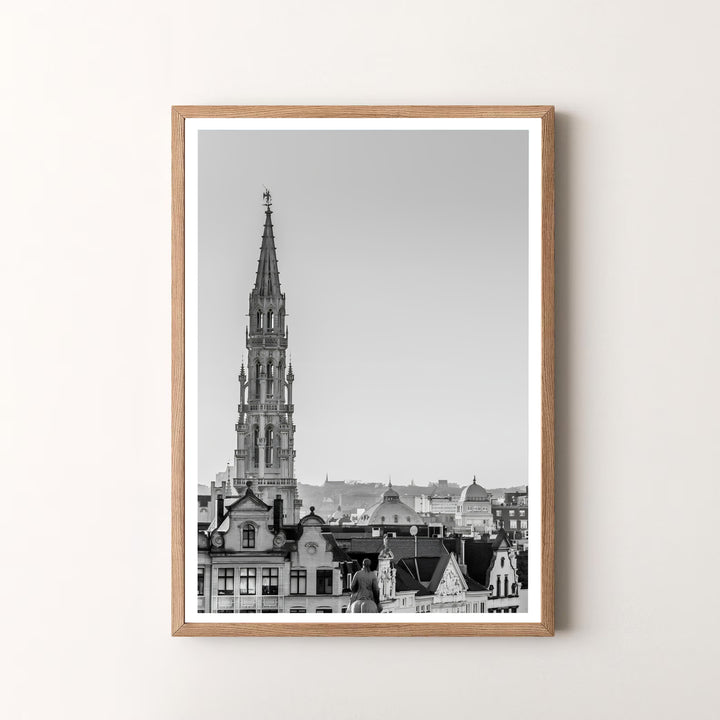 A striking black and white skyline print highlighting the majestic Gothic spire and historic architecture of Brussels, Belgium. Offered by MapYourDreams, this artwork is available in flexible options including unframed paper, custom wooden frames, and gallery canvas wraps.